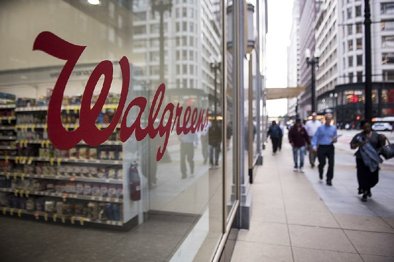 Pedestrians pass a Walgreens store in downtown Chicago in this file photo. The company’s attempt to buy drugstore rival Rite Aid has been slowed by concerns from federal antitrust regulators.