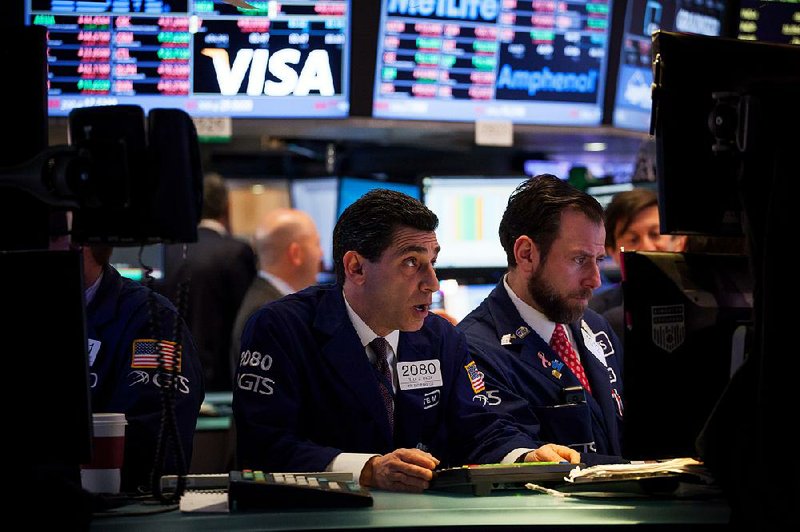 Traders work Monday on the floor of the New York Stock Exchange.
