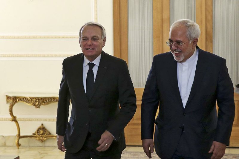 Iranian Foreign Minister Mohammad Javad Zarif (right) and French counterpart Jean-Marc Ayrault arrive for their meeting Tuesday in Tehran, Iran.