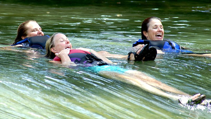 File Photo by Randy Moll Robyn Nolen (left), Kerri Vollmer and Amy Witte float over the Illinois River rapids at the Siloam Springs Kayak Park on July 21, 2016.