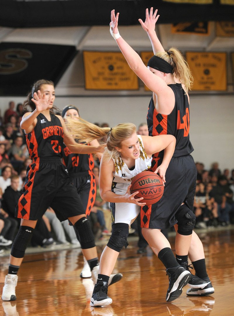 West Fork's Mesa Kutz (center) makes a move around Stephanie Pinter (right) of Gravette on Tuesday at the Tiger Dome in West Fork. Visit nwadg.com/photos for more pictures from the game.