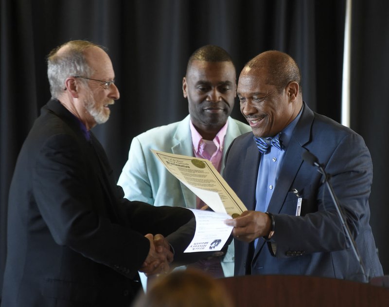 John L Colbert (right), associate superintendent, shakes hands Tuesday with Fayetteville Mayor Lionel Jordan, after Jordan presented a proclamation during a news conference to kick off Black History Month at the West Campus Agee Lierly Life Preparation Services Center in Fayetteville.