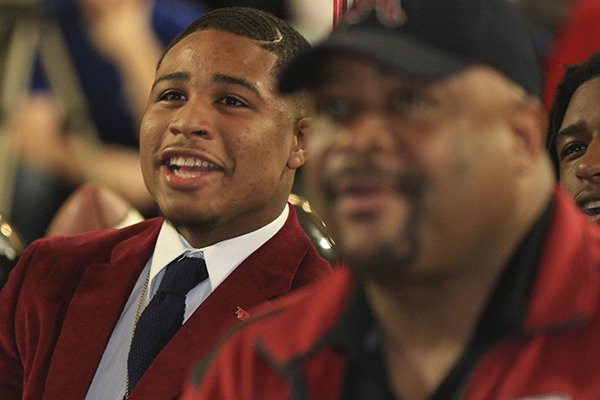 Receiver Koilan Jackson, left, and his father Keith watch during a signing ceremony at Joe T. Robinson High School in Little Rock on Wednesday, Feb. 1, 2017. 