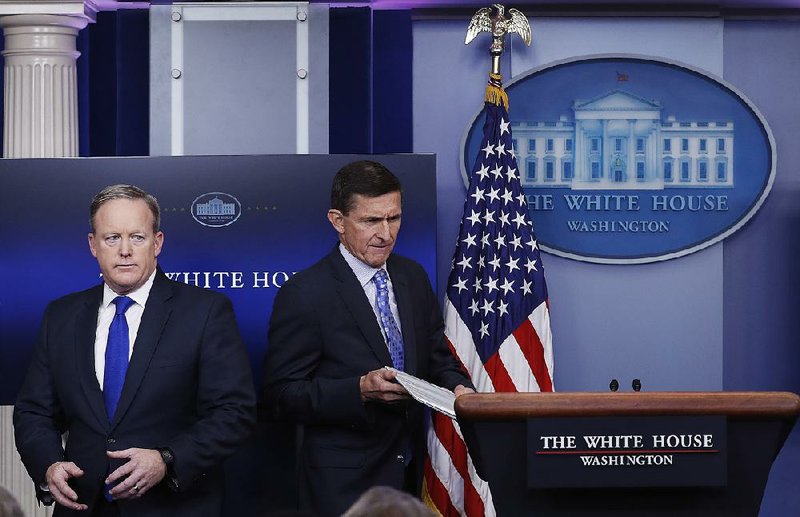 Michael Flynn walks past White House spokesman Sean Spicer (left) to take the podium Wednesday for the daily news briefing at the White House.