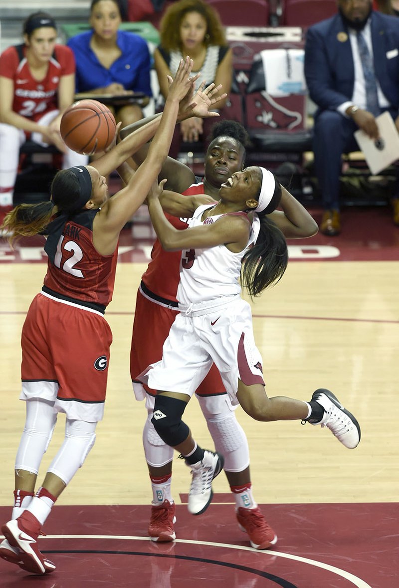 NWA Democrat-Gazette/MICHAEL WOODS @NWAMICHAELW Arkansas guard Malica Monk (3) is fouled as she tries to drive past Georgia defenders Haley Clark (12) and Stephanie Paul on Thursday at Bud Walton Arena in Fayetteville.