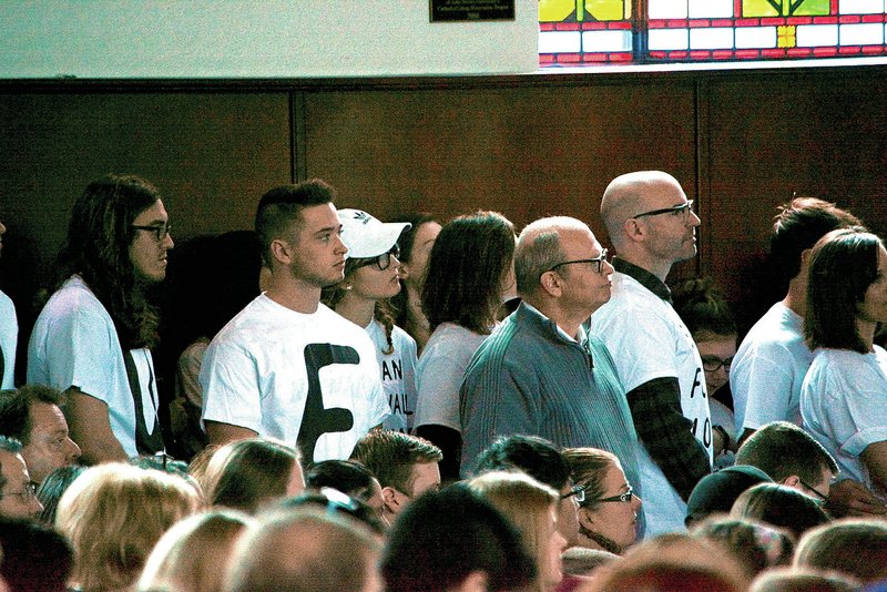 A group of about 50 students and alumni stood in protest Thursday while Mike Huckabee, former Arkansas governor and presidential candidate, spoke at John Brown University’s chapel service.