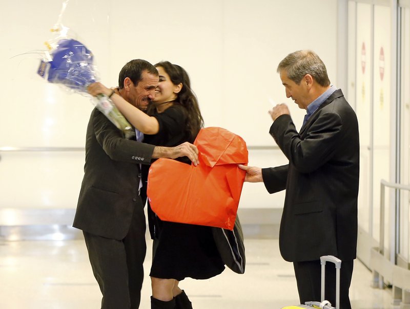 Ali Vayeghan, an Iranian citizen with a valid U.S. visa, left, is kissed by his niece Marjan Vayghan, as his brother Houssein Vayghan welcomes hism as he arrives at Los Angeles International Airport Thursday, Feb. 2, 2017. 