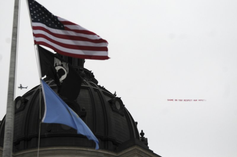 An airplane circles the South Dakota Capitol in Pierre, S.D., with a banner that reads: "Shame on you! Respect our vote!" on Wednesday, Feb. 1, 2017. 