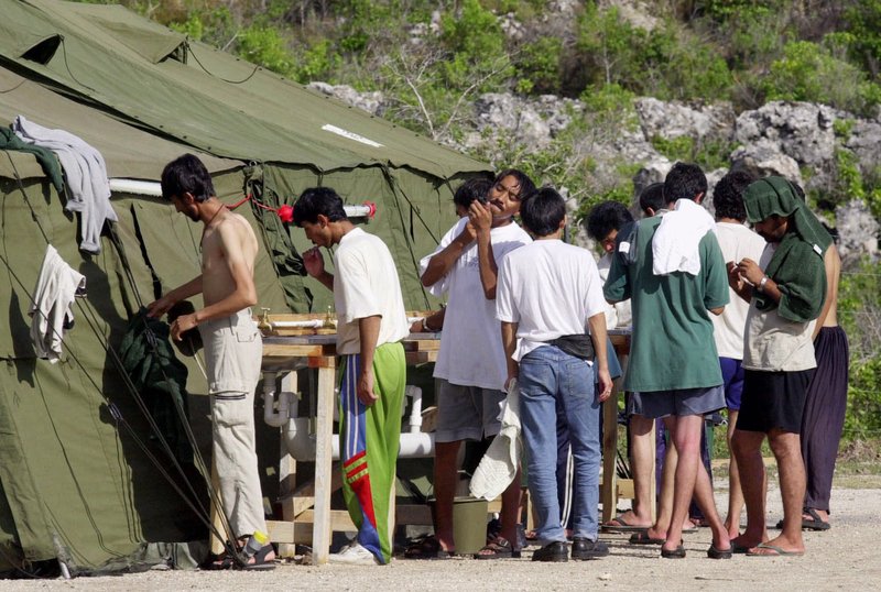 In this Sept. 21, 2001, file photo, men shave, brush their teeth and prepare for the day at a refugee camp on the Island of Nauru. Australia's Prime Minister Malcolm Turnbull insisted Thursday, Feb. 2, 2017, that a deal struck with the Obama administration that would allow mostly Muslim refugees rejected by Australia to be resettled in the United States was still on, despite President Donald Trump dubbing the agreement "dumb" and vowing to review it. 