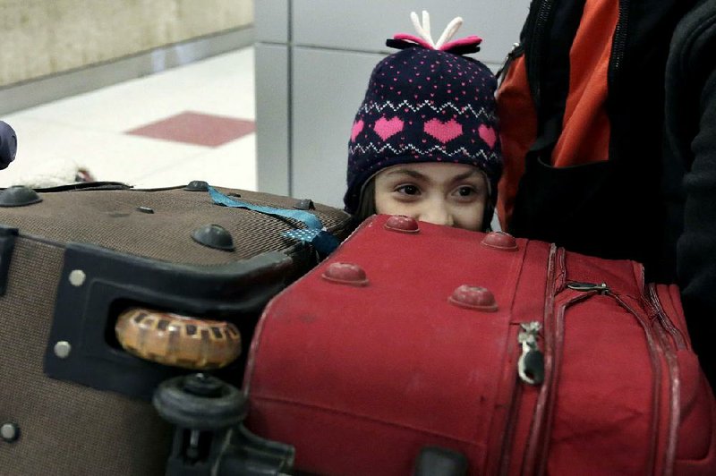 Dima Alaskry, daughter of Munther Alaskry, a former interpreter for the U.S. military in Iraq, arrives with her family Friday at the airport in New York after Alaskry and other former interpreters werAP/RICHARD DREW 
