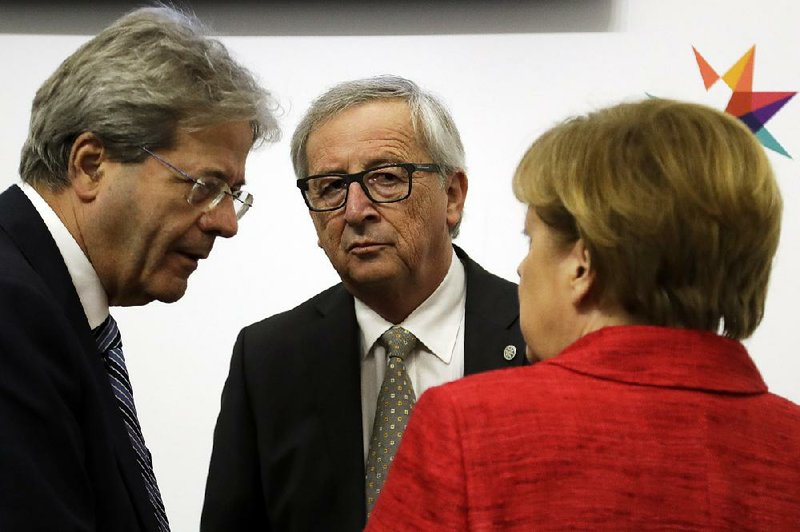 Italian Premier Paolo Gentiloni (from left), European Commission President Jean-Claude Juncker and German Chancellor Angela Merkel confer during an EU summit Friday in Valletta, Malta. 