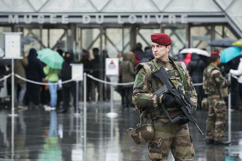 A French soldier patrols Saturday outside the Louvre after the museum reopened to visitors. 