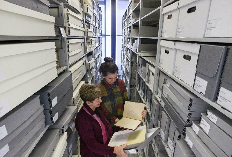 Director Deborah Baldwin (left) and assistant director Kimberly Kaczenski retrieve documents from the University of Arkansas at Little Rock’s Center for Arkansas History and Culture storage space, where materials generated by the Harrison Community Task Force on Race Relations will soon be archived. 
