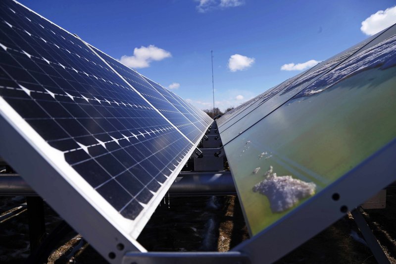 In this Feb. 26, 2015 file photo, solar panels that are part of the Wright-Hennepin Cooperative Electric Association's community gardens are shown in Rockford, Minn. Plunging solar power costs are leading U.S. electric companies to capture the sun just when President Donald Trump is moving to boost coal and other fossil fuels. 