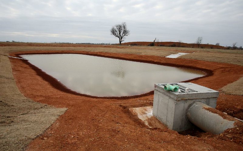 One of seven ponds being built along the west side of Interstate 49 near Lowell is shown Thursday. The ponds, within the Cave Springs recharge area, are not for fi shing but to help protect the blind Ozark cave fish and other sensitive, threatened or endangered creatures that live in the recharge area, according to state highway officials.
