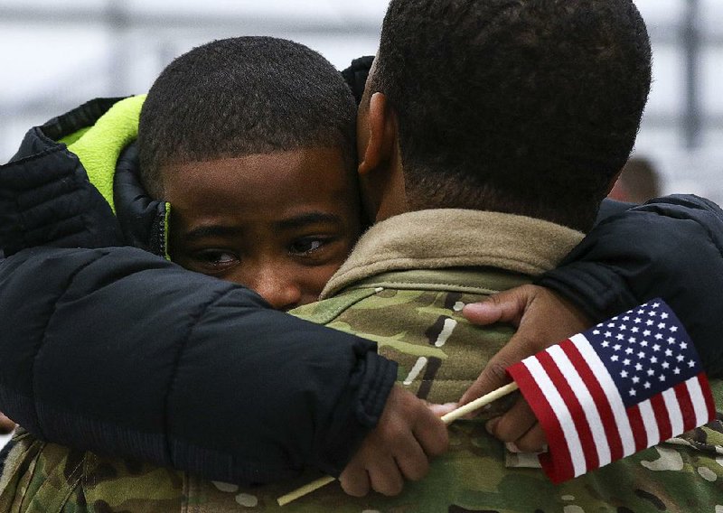 Seven-year-old Brandon Thomas Jr. of North Little Rock hugs his father, Spc. Brandon Anderson-Thomas of Company A, 2nd Battalion, 149th General Support Aviation, on Sunday during the deployment ceremony for two companies of the 77th Combat Aviation Brigade of the Arkansas National Guard at Camp Robinson Maneuver Training Center in North Little Rock.