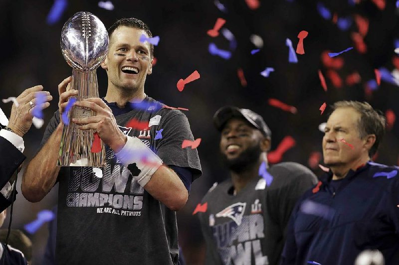 New England quarterback Tom Brady holds the Vince Lombardi Trophy after leading the Patriots to a comeback victory over Atlanta on Sunday to win his fi fth Super Bowl title, which tied Charles Haley for the most all-time by a single player.