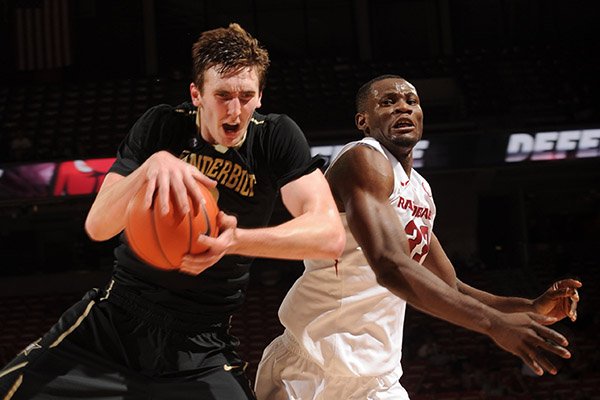 Arkansas forward Moses Kingsley (33) and Vanderbilt forward Luke Kornet (left) vie for a loose ball Tuesday, Feb. 7, 2017, during the second half of play in Bud Walton Arena in Fayetteville.
