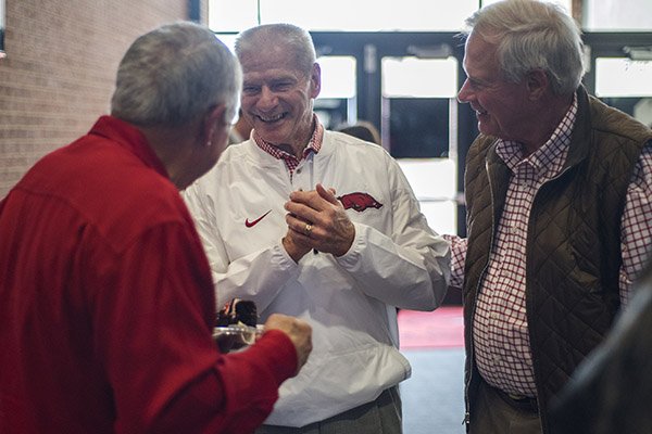 Former Arkansas baseball coach Norm DeBriyn, (center) visits with friends Monday, Feb. 6, 2017, during a reception to honor DeBriyn's retirement from the Razorback Foundation. DeBriyn coached the Diamond Hogs from 1970 to 2002, and has worked at the Razorback Foundation since. More than 100 people came to congratulate DeBriyn and wish him well on his retirement.	