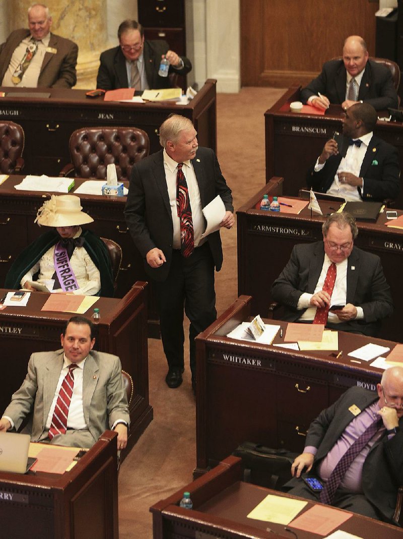 Rep. Dan Douglas makes his way to the front of the House chamber Tuesday to present his bill to recoup Internet sales tax money. The bill was approved, as was a similar measure in the Senate on Monday. 