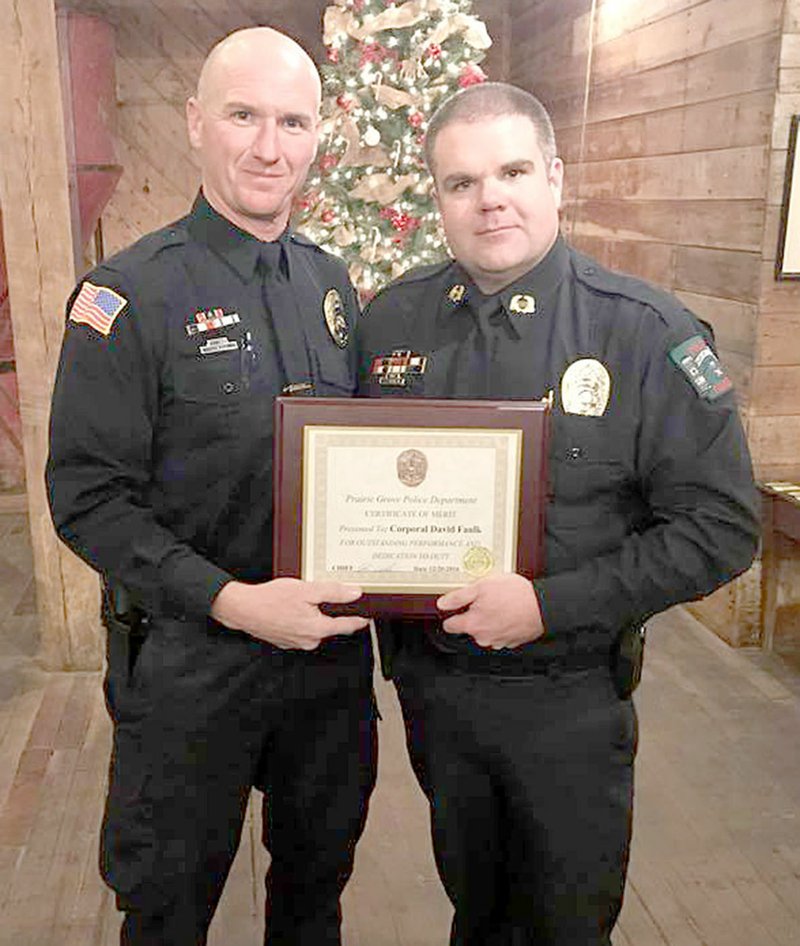 COURTESY PHOTO Cpl. David Faulk with Prairie Grove Police Department, left, was awarded the Certificate for Merit for his hard work, dedication and accomplishments during the year 2016. Chief Chris Workman presented the award to Faulk.