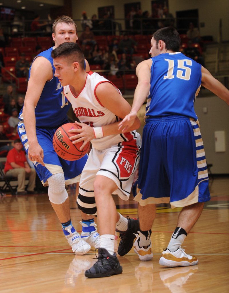 NWA Democrat-Gazette/ANDY SHUPE Skyler Montez (center) of Farmington drives past Trevor Atwell (left) and Jake Wynn of Harrison Tuesday, Jan. 24, 2017, during the first half of play in Cardinal Arena in Farmington. Visit nwadg.com/photos to see more photographs from the game.