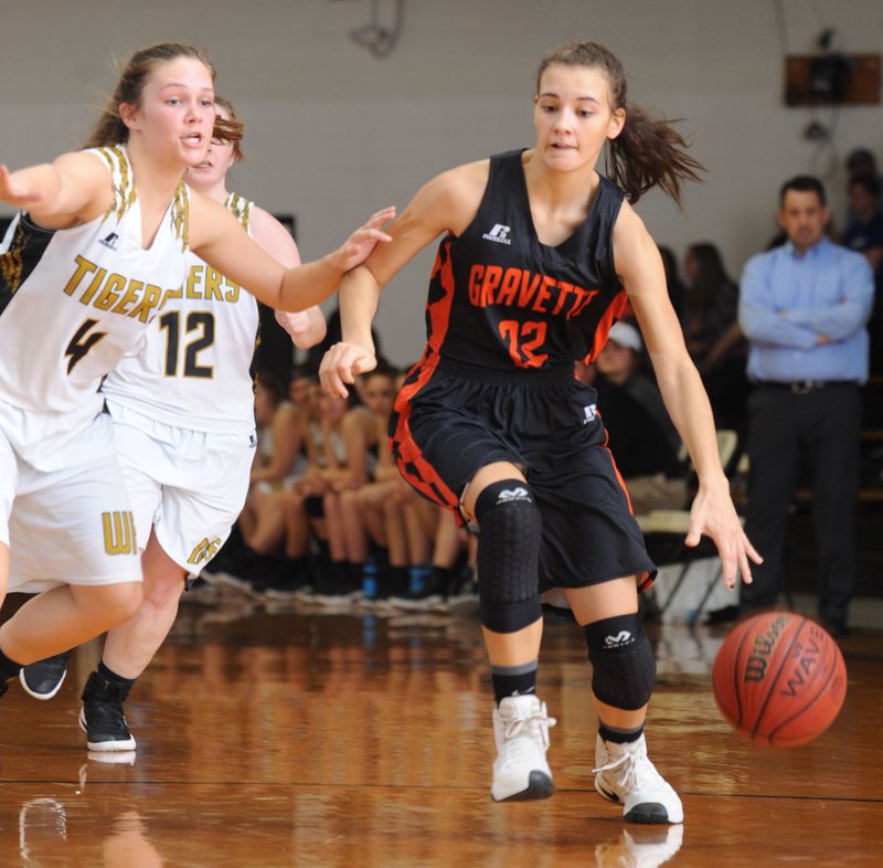Gravette guard Tori Foster (22) drives around Cassie Cartwright of West Fork on Jan. 31 at the Tiger Dome in West Fork.
