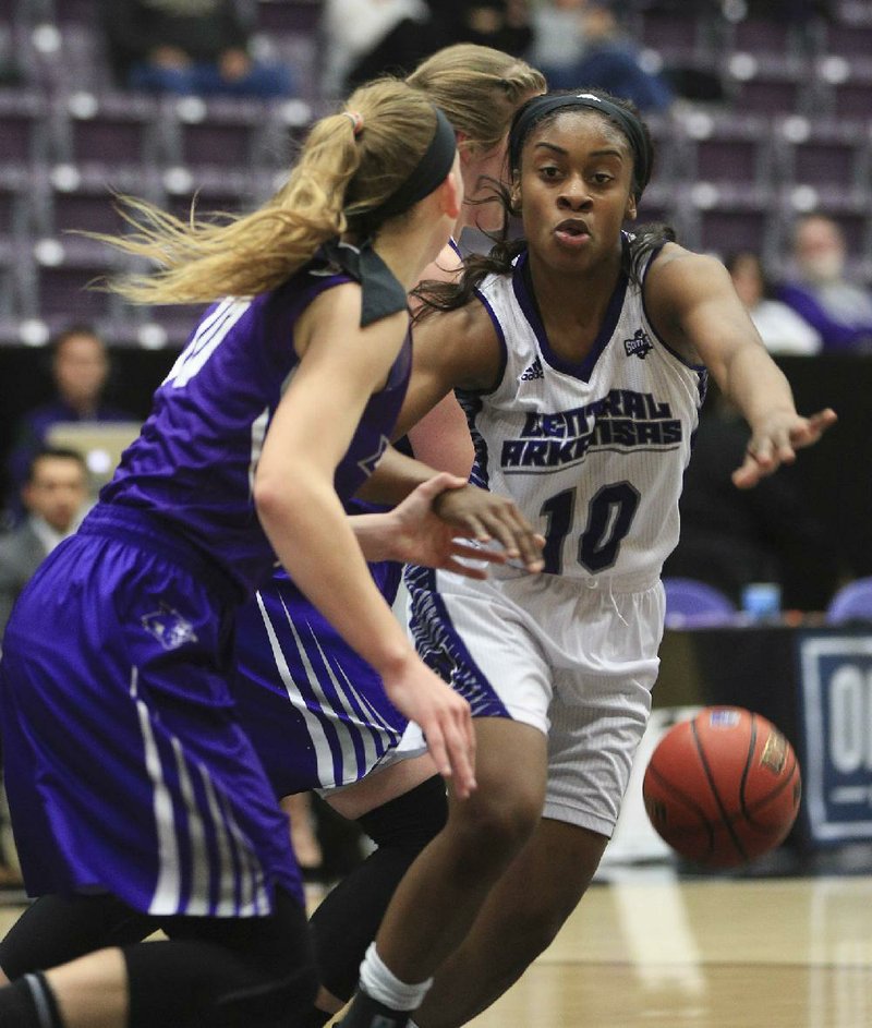 Central Arkansas guard Brianna Mullins (right) tries to take the ball from Abilene Christian guard Breanna Wright during Wednesday’s game at the Farris Center in Conway. Mullins had 10 points and eight assists as the Sugar Bears took over first place in the Southland Conference with an 80-70 victory.