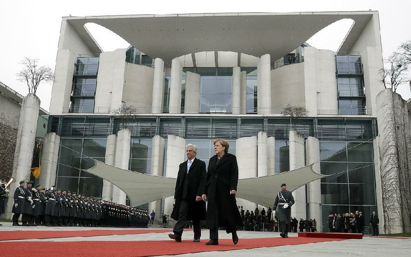 German Chancellor Angela Merkel welcomes the president of Uruguay, Tabare Vazquez Rosas, with a military honor guard before a meeting Wednesday at the chancellery in Berlin. 
