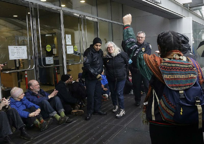 An opponent of the Dakota Access oil pipeline is arrested Wednesday as she and others block an entrance to the federal building in San Francisco. 
