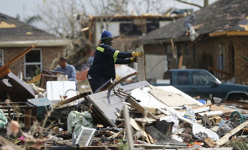 Willie Anderson tries to salvage possessions Wednesday from his daughter’s home that was destroyed by a tornado Tuesday in New Orleans.  