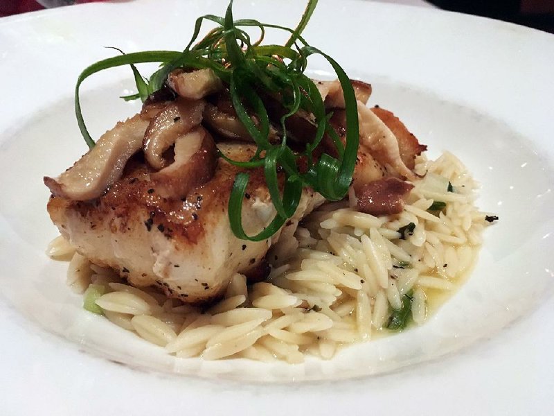 The Pan Seared Sea Bass, sauteed with with shiitake mushrooms in a delicate lemon beurre blanc, comes on a bed of grilled scallion orzo at So Restaurant Bar. 