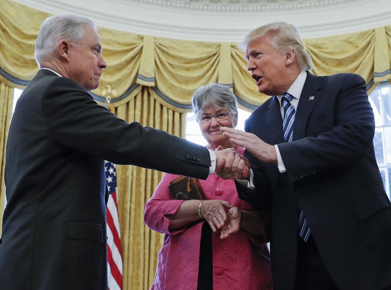 President Donald Trump shakes hands with Attorney General Jeff Sessions, accompanied by his wife Mary, after he was sworn-in by Vice President Mike Pence, Thursday, Feb. 9, 2017, in the Oval Office of the White House in Washington. (AP Photo/Pablo Martinez Monsivais)
