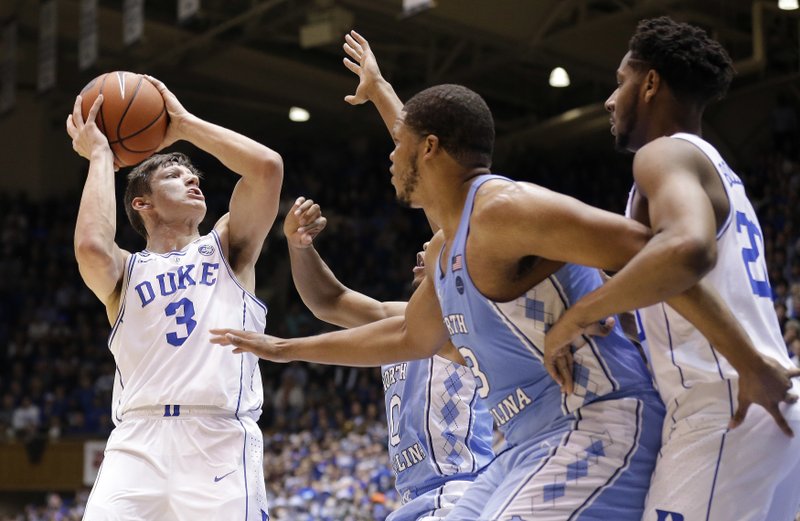 Duke's Grayson Allen (3) looks to shoot while North Carolina's Nate Britt, rear, and Kennedy Meeks (3) defend as Duke's Marques Bolden watches at right during the first half of an NCAA college basketball game in Durham, N.C., Thursday, Feb. 9, 2017. (AP Photo/Gerry Broome)