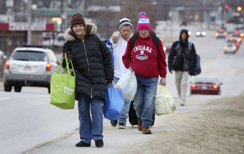 Stephanie Regan walks down South School Avenue last week on her way to breakfast at the 7 Hills Day Center. After a cold night, a line of more than 20 people will begin to form about 7:30 a.m. for entry into the center. For more photos, visit nwaonline.com.