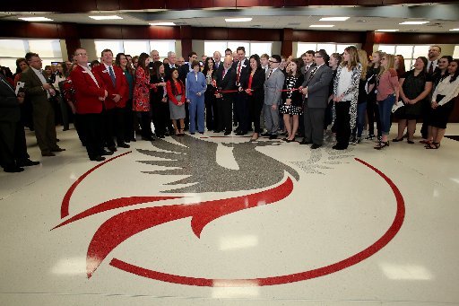 John Tyson (center), chairman of the board for Tyson Foods, cuts a ribbon Thursday, February 9, 2017, during a dedication ceremony for Springdale's new Don Tyson School of Innovation campus. The school is named after Donald Tyson former chairman and chief executive officer of Tyson Foods. Half of the campus opened in August, with construction wrapping up on the other half in time for this semester.