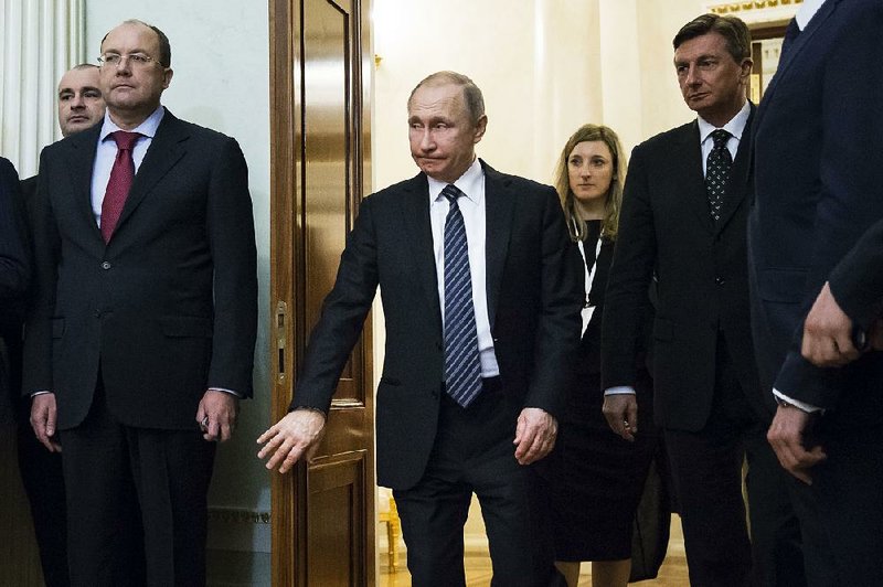 Russian President Vladimir Putin (center) and Slovenian President Borut Pahor (right) enter a hall for a signing ceremony after their talks Friday at the Kremlin.