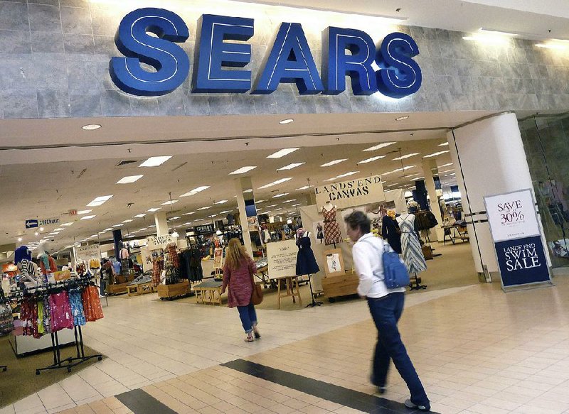 Shoppers enter a Sears store in Peabody, Mass., in this file photo. The struggling retail chain is looking for ways to cut costs, the company said Friday.