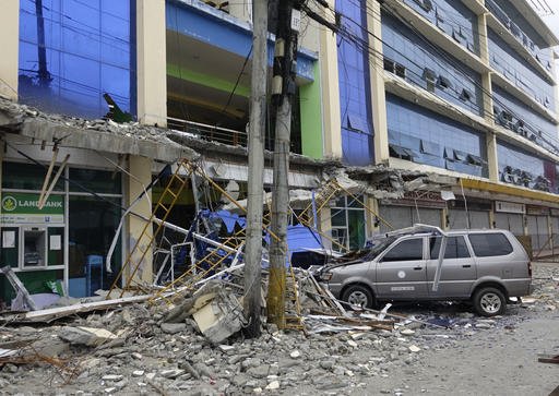 Fallen debris from a building are seen Saturday, Feb. 11, 2017, after a powerful nighttime earthquake that rocked Surigao city, Surigao del Norte province, in southern Philippines. 