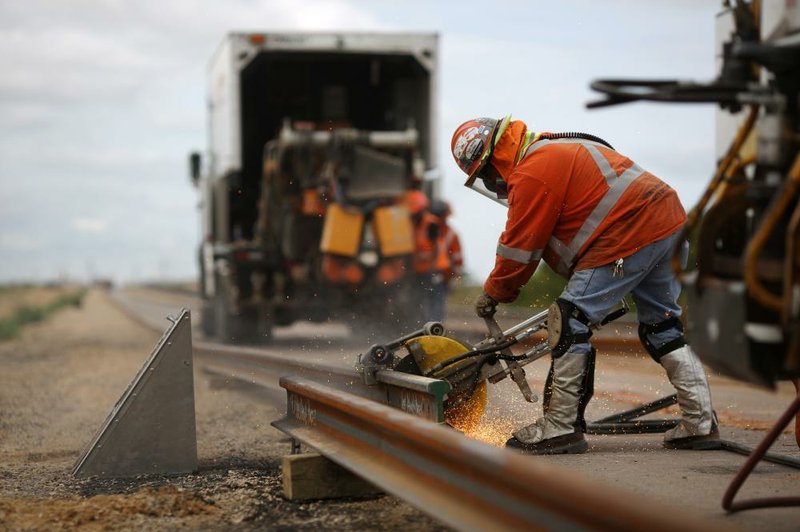 A worker links a new BNSF Railway rail in Alva, Okla., in 2015. BNSF is one of several railroads that are fighting an effort to make them responsible for compliance with a biofuel rule.
