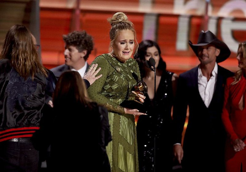 Adele accepts the award for album of the year for 25 at the 59th annual Grammy Awards on Sunday in Los Angeles.