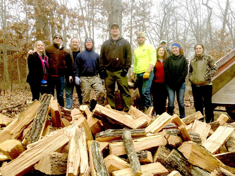 Photo submitted Members of the Facebook group, Positively Bella Vista, posed for a photo before stacking the wood that was donated by Bunting Tree Service to help a neighbor. They are Jo Lowrey, Chris Taylor, Steve Montz, Josh Soto, Joe Becker, Josh Bunting, Dixie Jenkins-Montz, Tom Ross, Jaylen Macy, and Kolla Bunting.