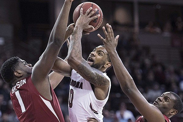 South Carolina guard Sindarius Thornwell (0) drives to the hoop against Arkansas forward Trey Thompson (1) and Manuale Watkins (21) during the first half of an NCAA college basketball game, Wednesday, Feb. 15, 2017, in Columbia, S.C. (AP Photo/Sean Rayford)
South Carolina guard Sindarius Thornwell (0) drives to the hoop against Arkansas forward Trey Thompson (1) and Manuale Watkins (21) during the first half of an NCAA college basketball game, Wednesday, Feb. 15, 2017, in Columbia, S.C. (AP Photo/Sean Rayford)