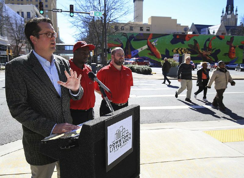 Gabe Holstrom (left), executive director of the Downtown Little Rock Partnership, introduces two downtown “ambassadors” — Donovan James (center), and Aaron Clark — on Wednesday. The ambassadors will help visitors and shoo away panhandlers. 