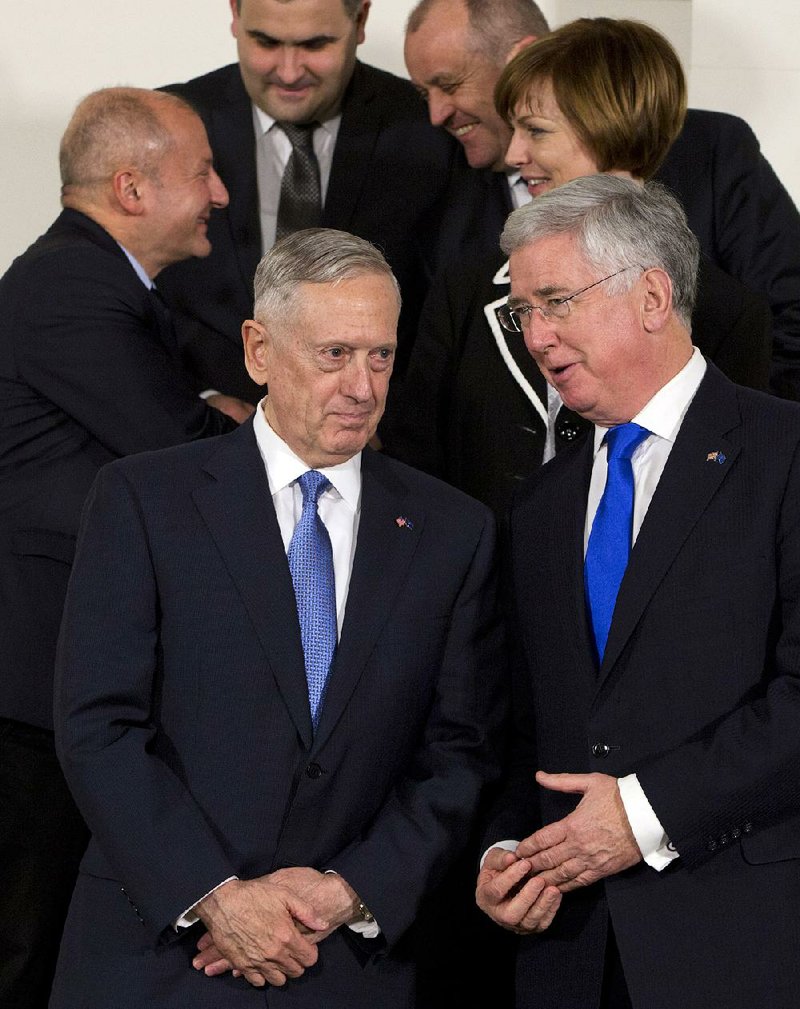 U.S. Secretary of Defense James Mattis (front left) speaks with British defense chief Michael Fallon during a group photo Wednesday at NATO headquarters in Brussels.