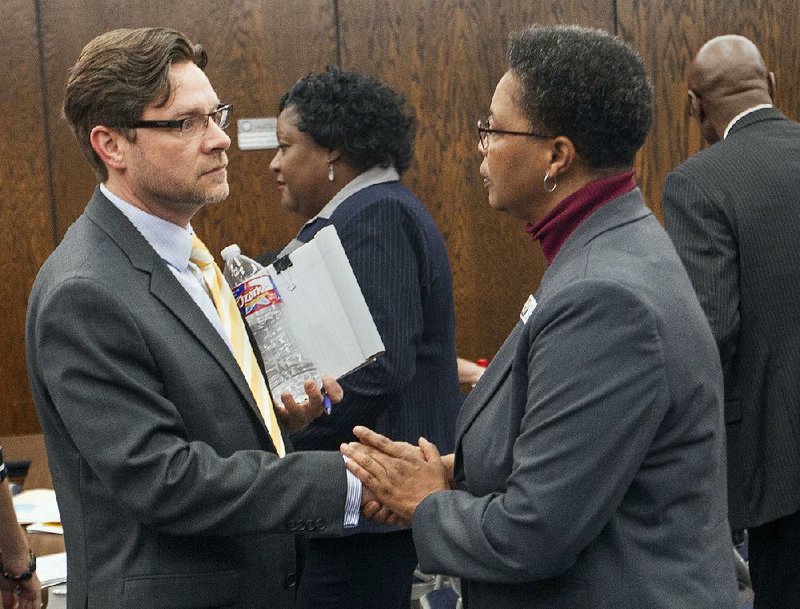 Charter Authorizing Panel member Annette Barnes (right) speaks to Scott Sides, head of school for the Arkansas Virtual Academy, about student enrollment numbers after Sides withdrew a request to expand the school’s enrollment cap. 