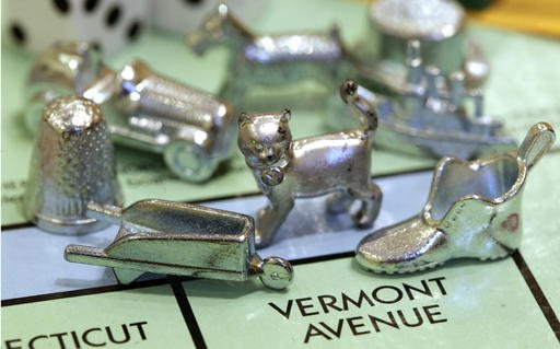 In this Feb. 5, 2013 file photo, the thimble game piece, left, sits among other Monopoly tokens at Hasbro Inc. headquarters in Pawtucket, R.I. 