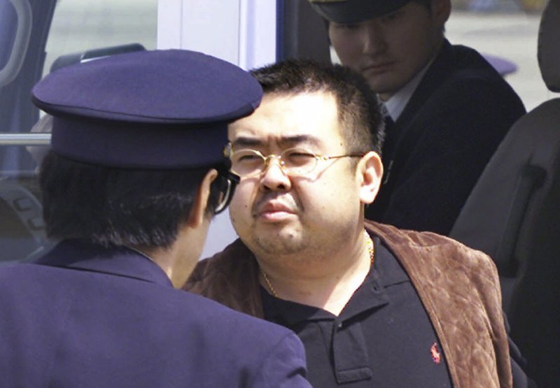 This May 4, 2001, file photo shows Kim Jong Nam, exiled half brother of North Korea's leader Kim Jong Un, escorted by Japanese police officers at the airport in Narita, Japan. 