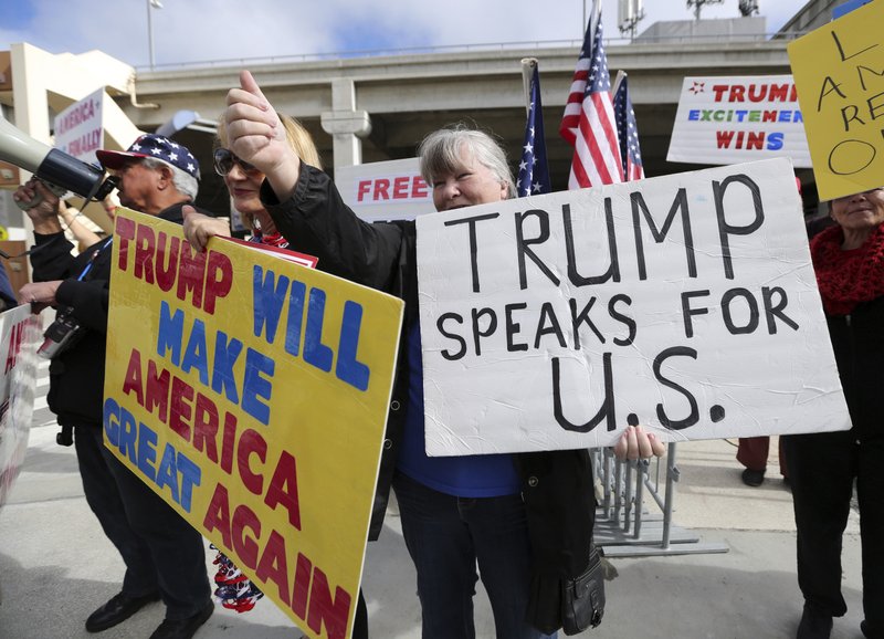 In this Feb. 4, 2017, file photo, a woman gives a thumbs up in Los Angeles, Calif., as demonstrators in favor of President Donald Trump's executive order banning travel to the U.S. from seven primarily Muslim nations stand across the street from the Tom Bradley International Terminal at Los Angeles International Airport.