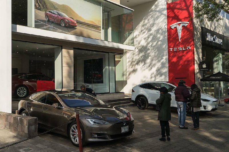 Customers check out Tesla vehicles outside a store in Mexico City earlier this year.